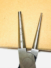 Metal pliers with measurement markings on a wooden background